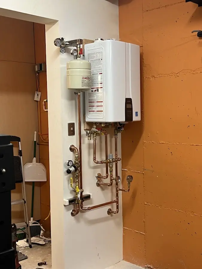 Plumbing technician inspecting water heater connections in Cheviot